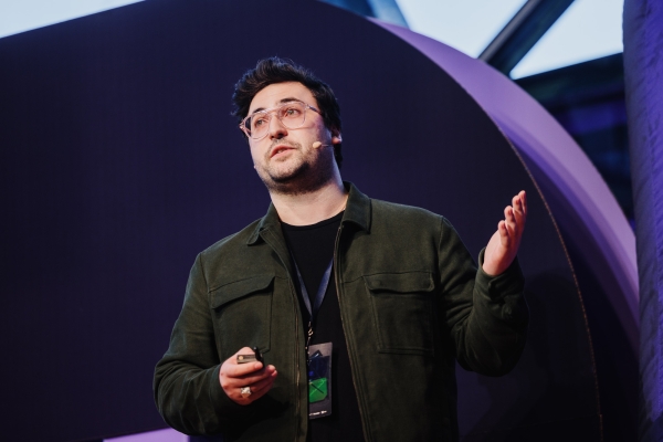 Peter Barber presenting at DO23, gesturing with his hands to the audience