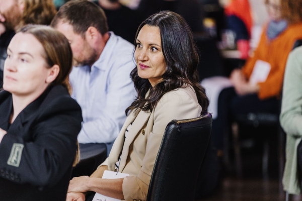 Pina Starchenko seated and attentively listening during a Design Leadership session, surrounded by other attendees.
