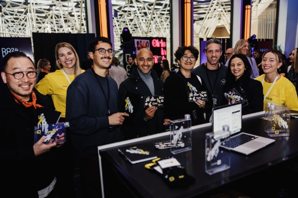 Attendees smiling with event swag in hand at Sofitel’s Sofi’s Lounge, in front of partner booths during Design Outlook 2024.