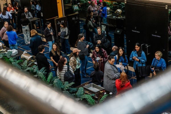 Attendees mingle over coffee during a break at The Outlook, gathered in the foyer outside Victoria Suites in a relaxed, social atmosphere.