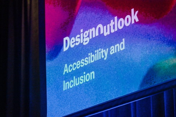 Close-up of a colourful screen at The Outlook displaying “Design Outlook – Accessibility and Inclusion” in bold white lettering.