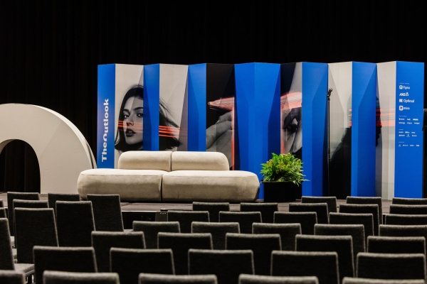 Stage setup at Design Outlook 2025, Sofitel Melbourne; featuring a beige couch, bold blue panels, and event branding in the background.