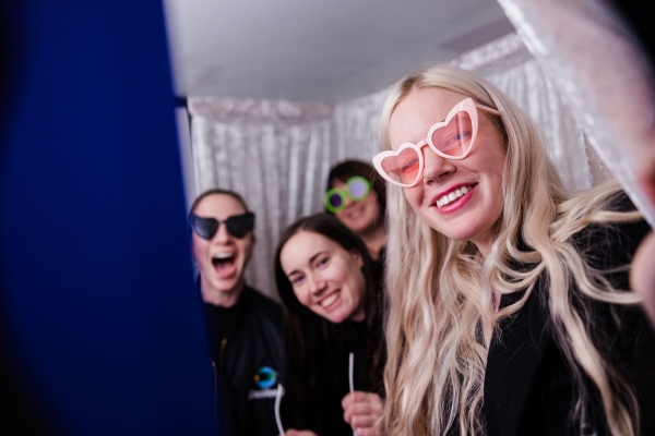 Attendees posing with playful sunglasses in the Torii photobooth at The Outlook 2025, smiling in front of a backgdrop.