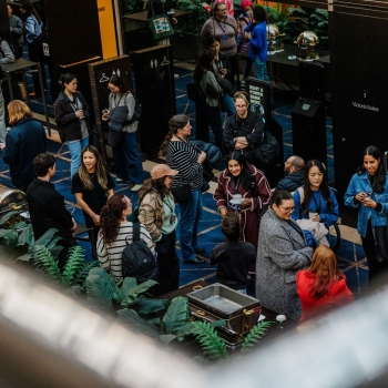 Attendees mingle over coffee during a break at The Outlook, gathered in the foyer outside Victoria Suites in a relaxed, social atmosphere.