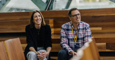 A photograph of two attendees of DO22 smiling at the stage
